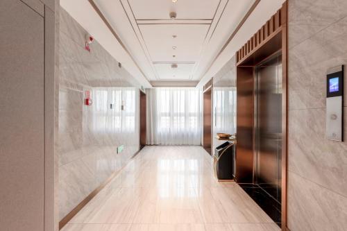 a hallway of a building with a elevator at 万信至格酒店乌鲁木齐机场德港万达店 in Ürümqi