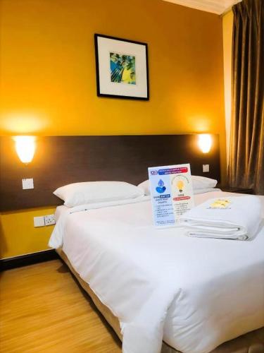 a hotel room with two beds with a sign on them at YMCA Kuala Lumpur in Kuala Lumpur