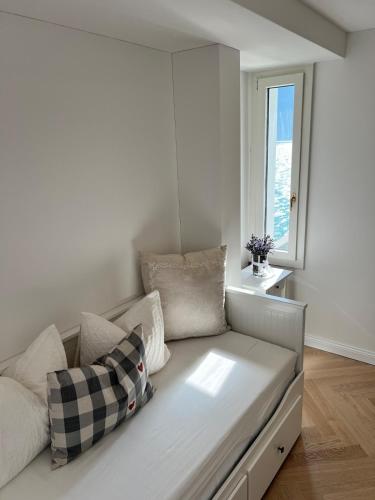 a white couch in a room with a window at Exclusive Lake Access Villa Studio in Fluelen