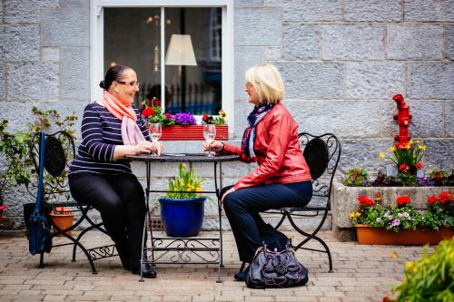 two women sitting at a table with flowers at Gleeson's Restaurant & Rooms in Roscommon