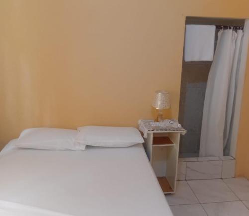 a bedroom with a white bed and a window at River view in Linstead
