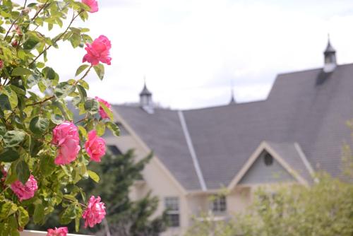 a bunch of pink flowers in front of a house at Hounds Tooth Inn in Oakhurst