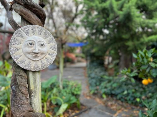 a statue of a face on a fence in a garden at The Retreat at Froog Moore Park in Tamworth