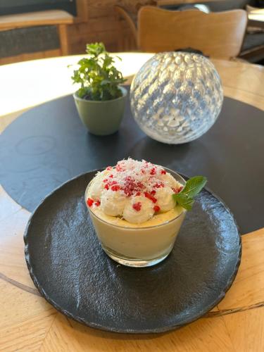 a bowl of ice cream on a plate on a table at Berggasthaus Eggberge - Boutique Mountain Hotel - Access via Cablecar in Altdorf
