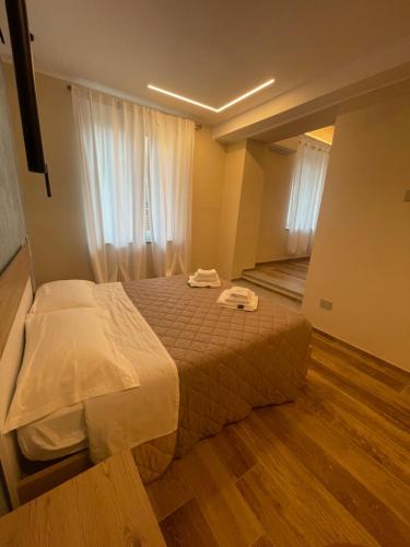 a bedroom with a bed and a window with white curtains at San Martino Lodge in Villanova dʼAsti