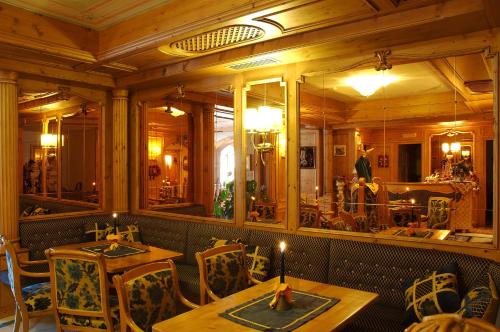 a dining room with tables and chairs and mirrors at Hotel Letizia in San Martino di Castrozza