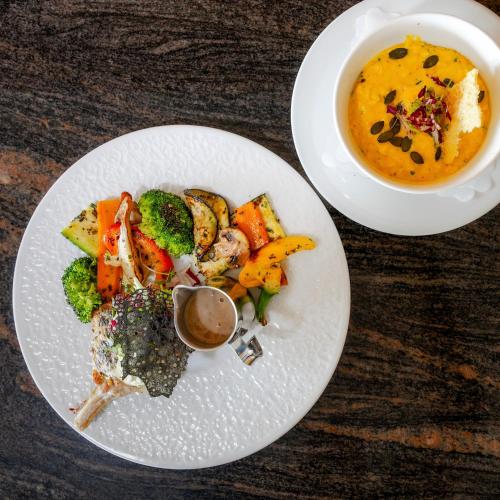 a plate of food and a bowl of soup on a table at Gartenhotel Maria Theresia in Hall in Tirol