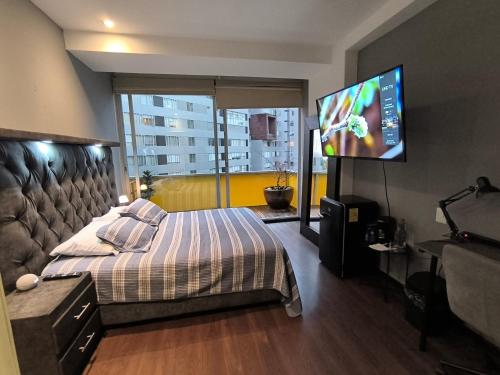 a bedroom with a bed and a flat screen tv at Cómoda habitación en Santa fe in Mexico City