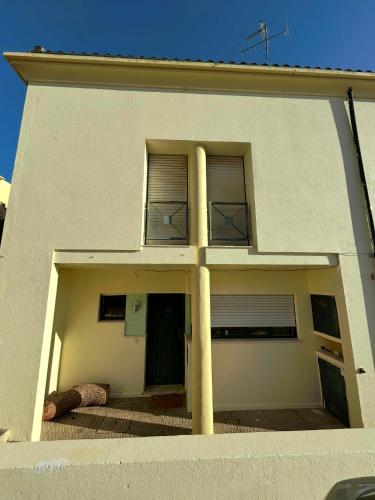 a white house with two columns in front of it at Cascais - Villa at Guincho Beach in Charneca