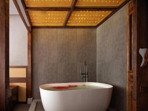 a white bath tub in a bathroom with a ceiling at Zhangjiajie SANHE Hotel --Free one way pick up service over 2 night, Free shuttle to east gate of forest park,Free laundry service,Free fresh coffee,English speaking customer service in Zhangjiajie