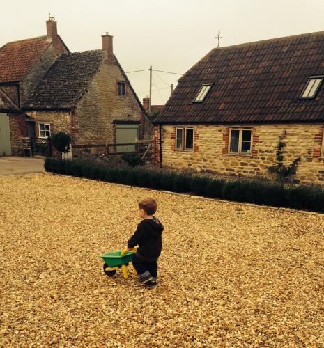 a young boy playing with a green frisbee at Rew Farm Country & Equestrian Accommodation - Sunrise Lodge in Melksham