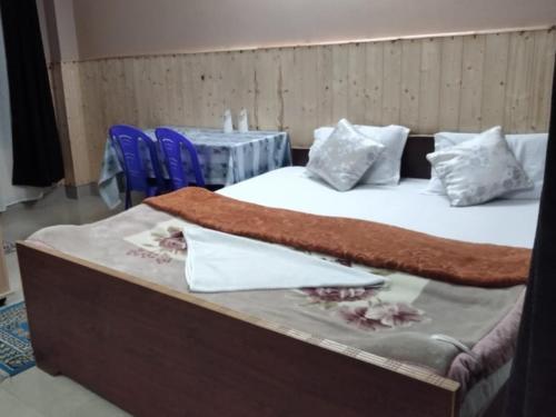a bed with white sheets and a blanket on it at Neel Pahari Homestay By StayApart in Pedong