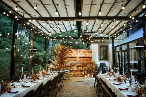 a dining room with long tables and chairs and lights at AMAYA HOME - Lodge, Spa & Restaurant in Hanoi