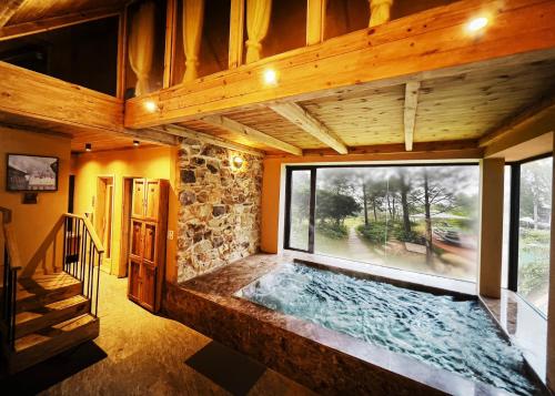 an indoor pool in a house with a large window at AMAYA HOME - Lodge, Spa & Restaurant in Hanoi
