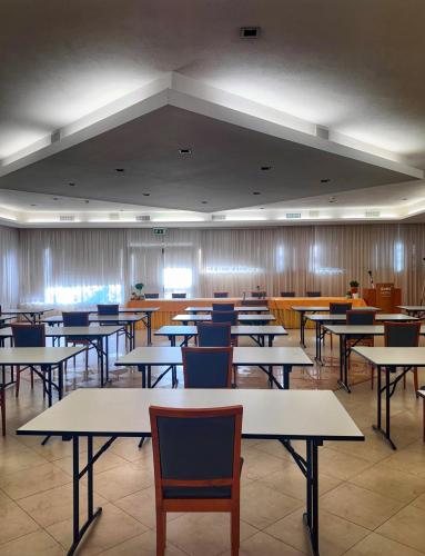 an empty classroom with tables and chairs in a building at Euro Hotel in Nuoro