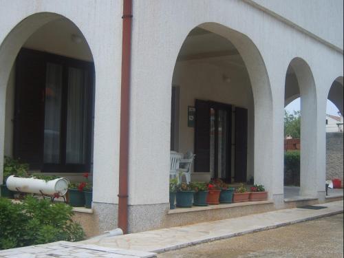 a building with three arches with potted plants on it at Apartments Zova in Medulin