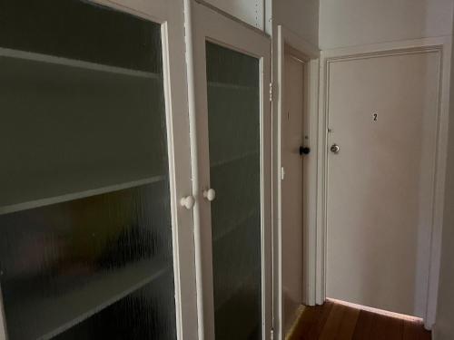 Habitación vacía con puerta de cristal y armario en Cozy single room, en Frankston