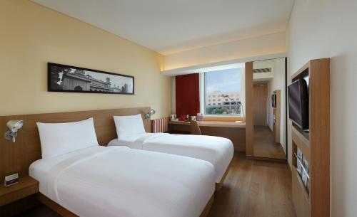 海得拉巴的住宿－ibis Hyderabad Hitec City - An Accor Brand，酒店客房设有两张床和电视。