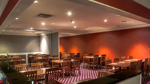 a dining room with wooden tables and chairs at Ramada by Wyndham Trenton in Trenton
