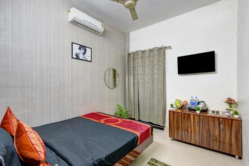 una camera da letto con un letto e una TV a schermo piatto di Hotel ALLEN STAY Uttam Nagar a Nuova Delhi