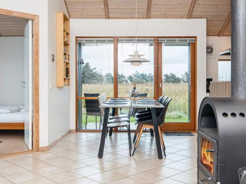 a dining room with a table and a fireplace at 7 person holiday home in Ulfborg-By Traum in Thorsminde