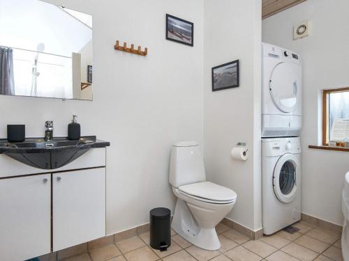 a bathroom with a toilet and a washer and dryer at 7 person holiday home in Ulfborg-By Traum in Thorsminde