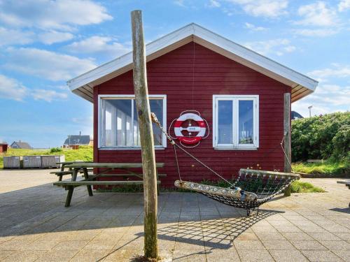 a red house with a hammock in front of it at 7 person holiday home in Ulfborg-By Traum in Thorsminde