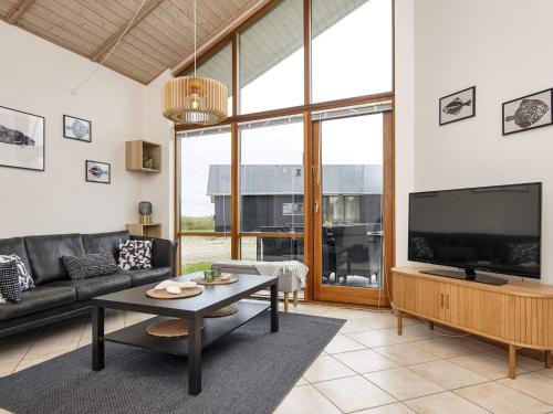 a living room with a couch and a tv at 7 person holiday home in Ulfborg-By Traum in Thorsminde