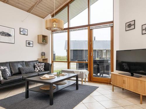 a living room with a couch and a tv at 7 person holiday home in Ulfborg-By Traum in Thorsminde