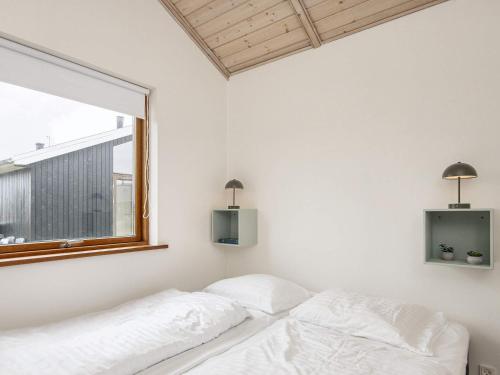 a white bedroom with a bed and a window at 7 person holiday home in Ulfborg-By Traum in Thorsminde
