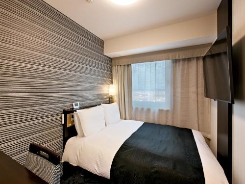 Ένα ή περισσότερα κρεβάτια σε δωμάτιο στο APA Hotel Niigata Tsubamesanjo Ekimae
