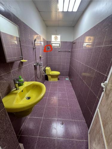 a bathroom with a yellow sink and a toilet at Maeen Rest House in Ma‘mad
