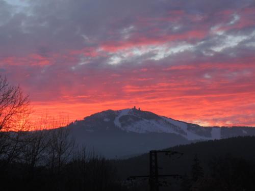 a sunset over a mountain with a person on top at Penzion 103 in Železná Ruda