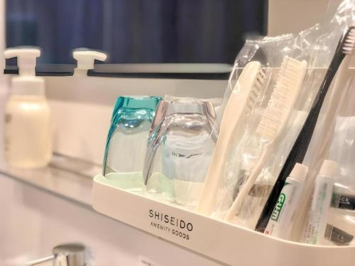 a shelf with toothbrushes and other items on a counter at KEIKYU EX INN Haneda Innovation City 2 minutes walk from HICity Exit of Tenkubashi Station in Tokyo