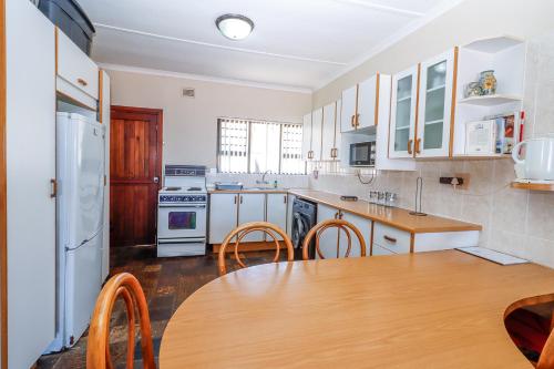 a kitchen with a table and a refrigerator at Natspat 14 in Margate