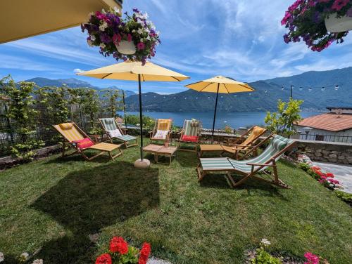 a group of chairs and umbrellas on a lawn at La Casa Della Seta in Mezzegra