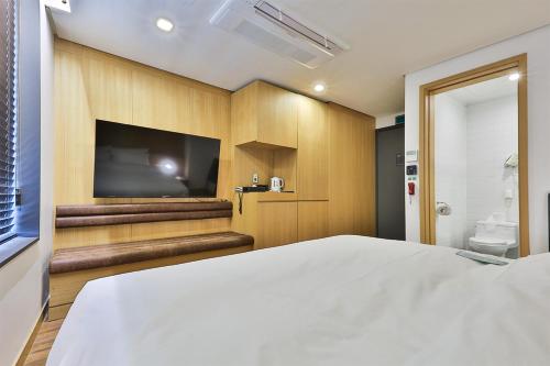 a bedroom with a large bed and a flat screen tv at MAKERS x IPPDA HOTEL in Seoul