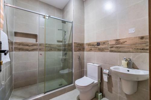 a bathroom with a toilet and a shower and a sink at 3 Bedroom Duplex for Shortlet in Ikota