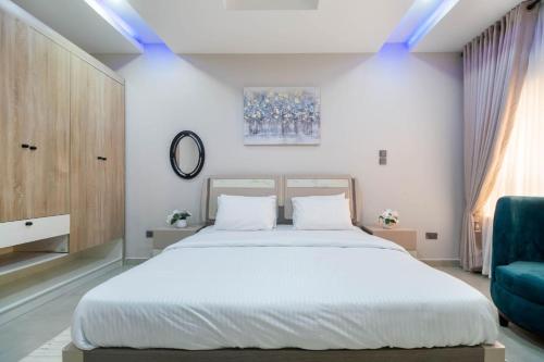 a bedroom with a large bed and a blue couch at 3 Bedroom Duplex for Shortlet in Ikota