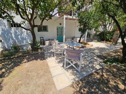 a patio with a table and chairs under a tree at Lemon Nest in Marathokampos