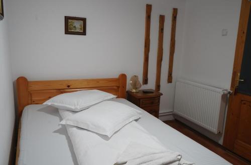 a bedroom with a bed with white sheets and pillows at Aquasalis in Câmpulung Moldovenesc