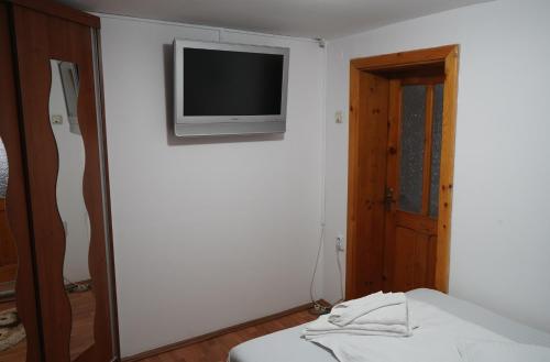a room with a bed and a television on a wall at Aquasalis in Câmpulung Moldovenesc