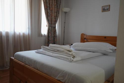 a bed with white sheets and pillows and a window at Aquasalis in Câmpulung Moldovenesc