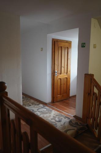 an empty hallway with a wooden door and a staircase at Aquasalis in Câmpulung Moldovenesc