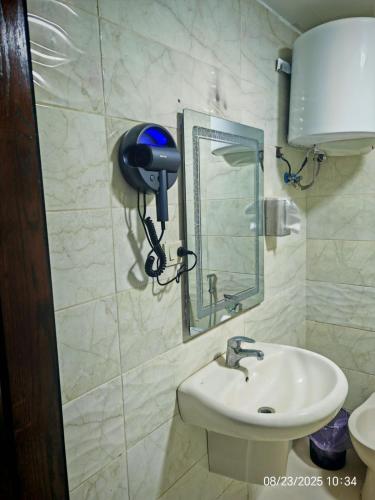 a bathroom with a sink and a hair dryer on the wall at EVANNA SUITE & HOTELs VIP ايفانا للشقق الفندقيه VIP in Amman