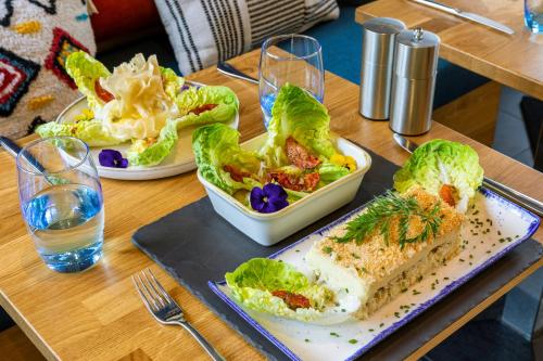 a table with two plates of salad and a sandwich at ibis Paris La Villette Cité des Sciences 19ème in Paris