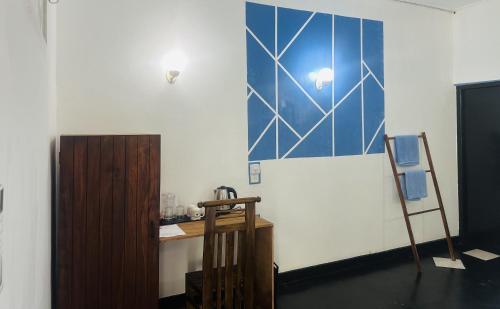 a room with a blue and white wall with a desk at Rock Hill Hotel in Galle