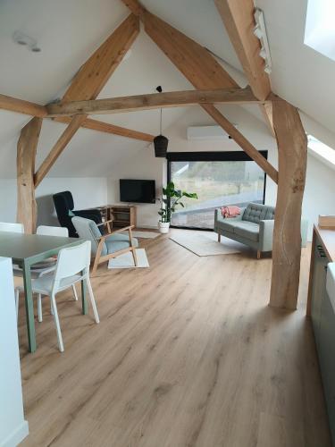 a living room with wooden beams and a table and chairs at Vakantiewoning De Woestijn - Den Ast in Roosdaal