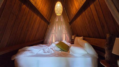a bedroom with a white bed with a light on it at Wilpattu Safari Resort in Wilpattu