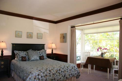 a bedroom with a bed and a desk and a window at Ojai Retreat & Inn in Ojai
